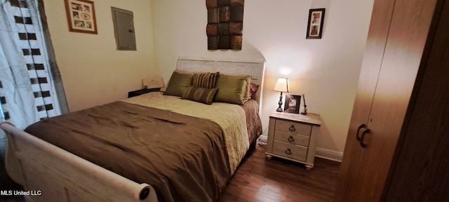 bedroom featuring electric panel and dark hardwood / wood-style flooring