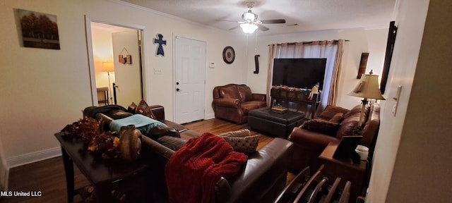 living room featuring crown molding, dark wood-type flooring, and ceiling fan