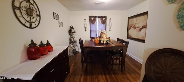 dining room with dark wood-type flooring and a textured ceiling