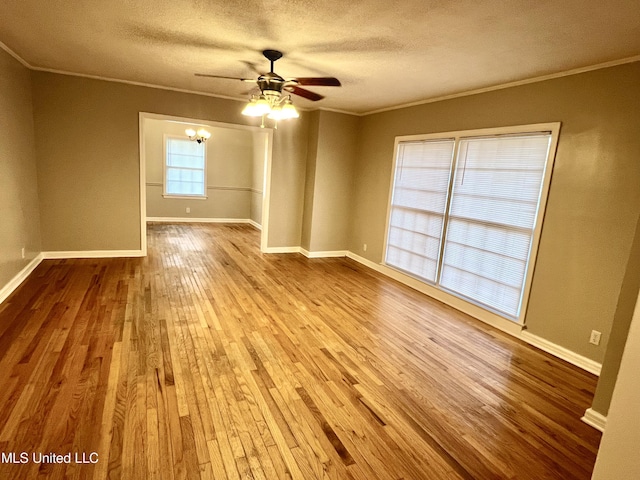 unfurnished room with ceiling fan, light wood-type flooring, a textured ceiling, and ornamental molding