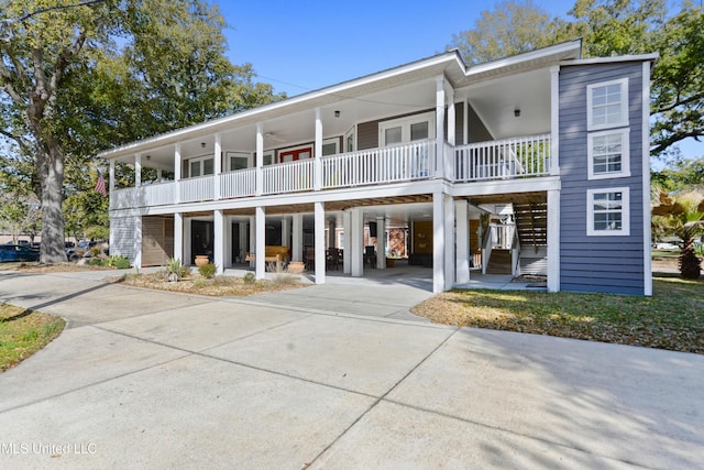 view of front facade featuring a carport, stairway, driveway, and a porch