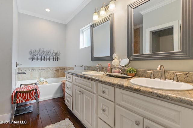 full bathroom featuring double vanity, ornamental molding, wood finished floors, and a sink