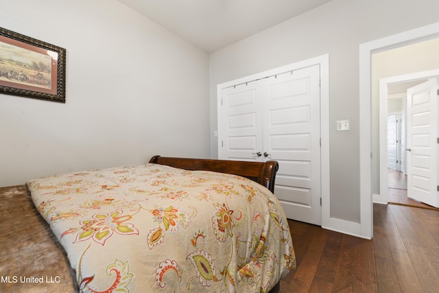 bedroom with a closet, baseboards, and dark wood-style flooring