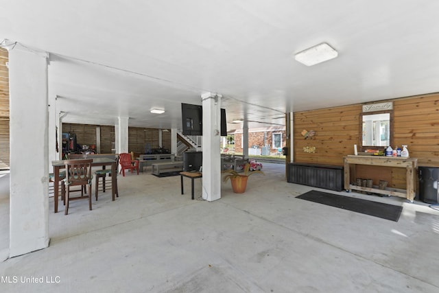 miscellaneous room with wood walls and concrete floors