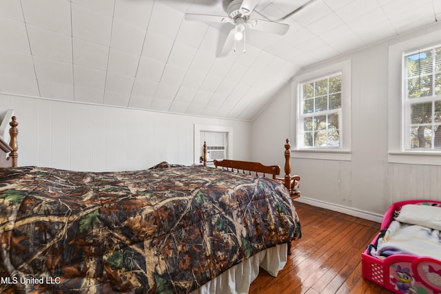 bedroom featuring lofted ceiling, hardwood / wood-style flooring, multiple windows, and cooling unit