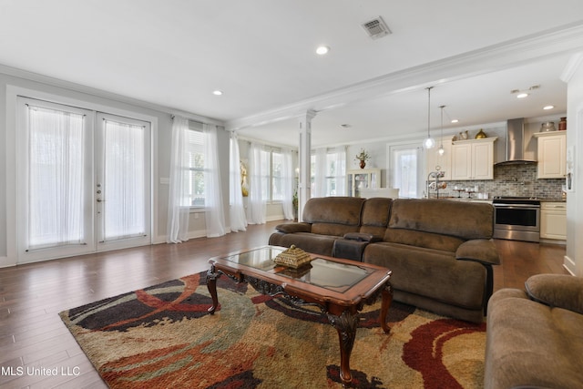 living room featuring visible vents, crown molding, dark wood-type flooring, decorative columns, and french doors