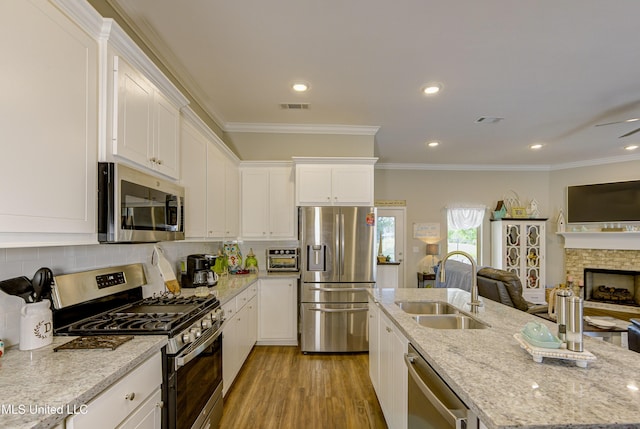 598 Westfield Dr, Pearl, MS 39208 - kitchen with appliances with stainless steel finishes, open floor plan, white cabinetry, an island with sink, and light wood-type flooring