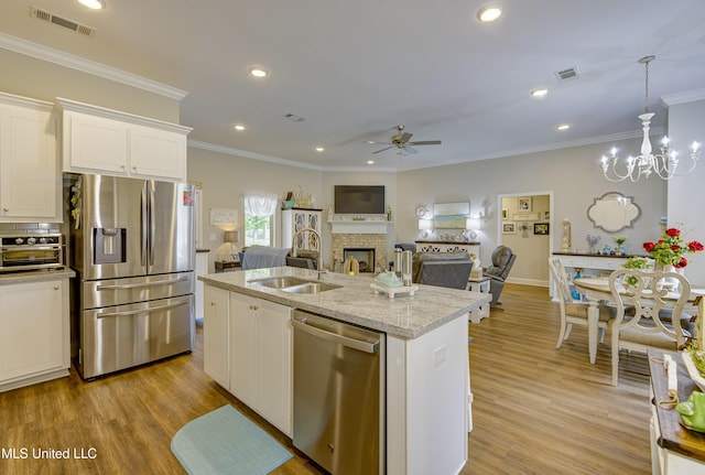 598 Westfield Dr, Pearl, MS 39208 - kitchen with stainless steel appliances, a ceiling fan, white cabinets, ornamental molding, and a fireplace