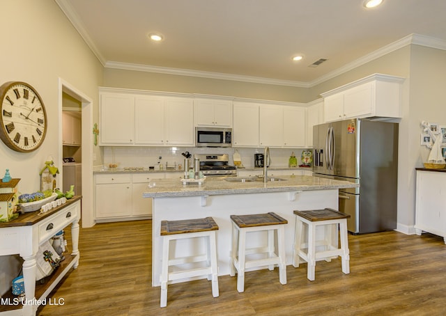 598 Westfield Dr, Pearl, MS 39208 - kitchen with stainless steel appliances, white cabinets, ornamental molding, a kitchen bar, and light stone counters
