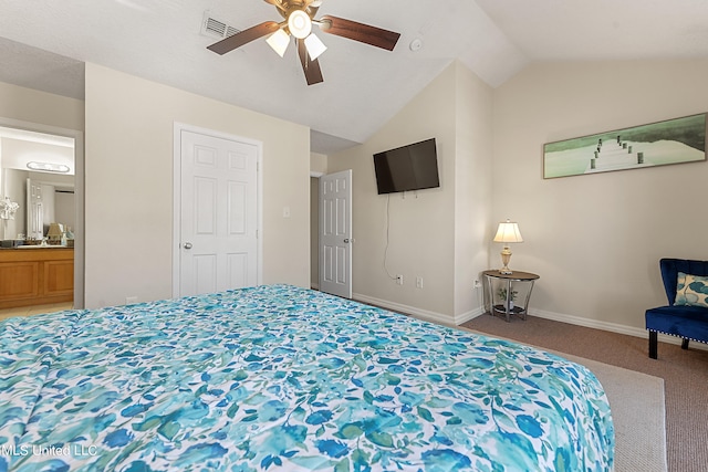 bedroom featuring vaulted ceiling, ensuite bath, carpet, and ceiling fan