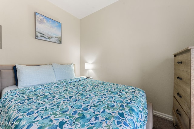 carpeted bedroom with lofted ceiling