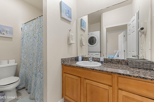 bathroom with vanity, stacked washer / drying machine, toilet, and tile patterned floors