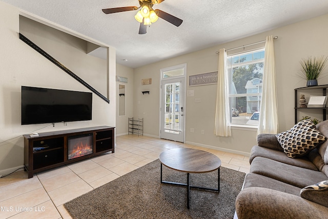 tiled living room with a textured ceiling and ceiling fan