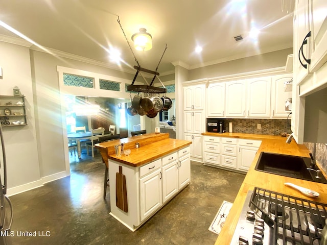 115 Pinedale Rd, Terry, MS 39170 - kitchen featuring butcher block countertops, concrete flooring, crown molding, white cabinets, and backsplash