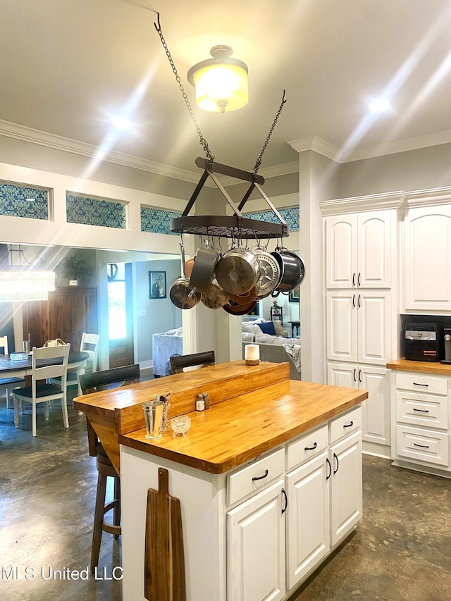 115 Pinedale Rd, Terry, MS 39170 - kitchen featuring butcher block countertops, finished concrete flooring, ornamental molding, white cabinetry, and a kitchen island