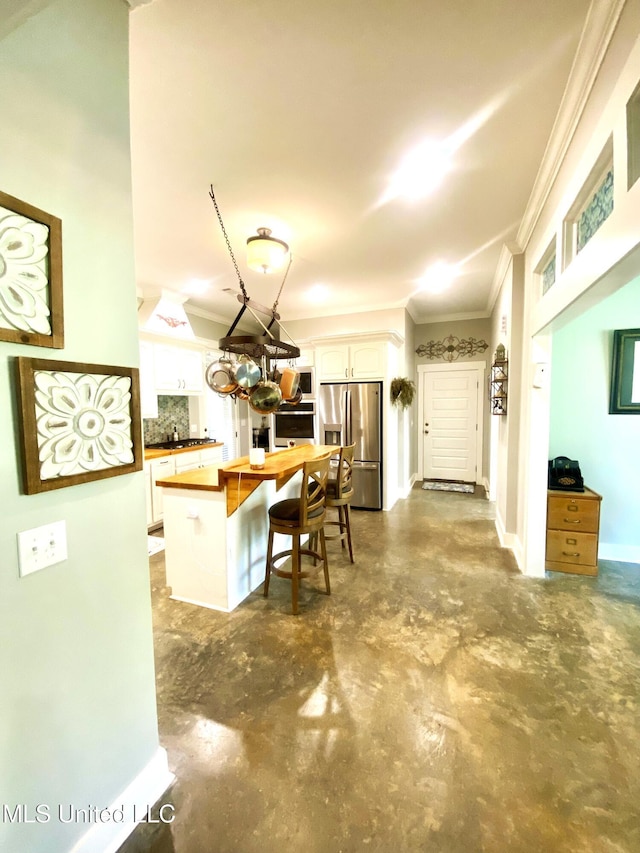 115 Pinedale Rd, Terry, MS 39170 - kitchen featuring appliances with stainless steel finishes, ornamental molding, concrete flooring, white cabinetry, and decorative backsplash