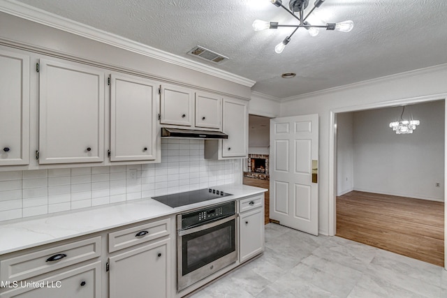 kitchen featuring a chandelier, black electric cooktop, hanging light fixtures, and stainless steel oven