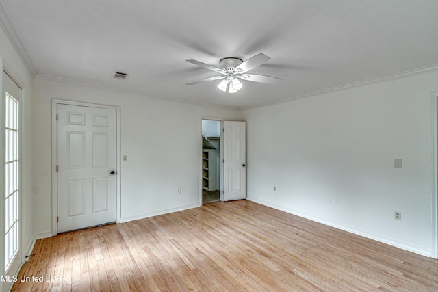 empty room with ceiling fan, light hardwood / wood-style floors, and crown molding