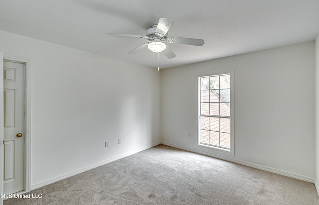 spare room with light colored carpet and ceiling fan