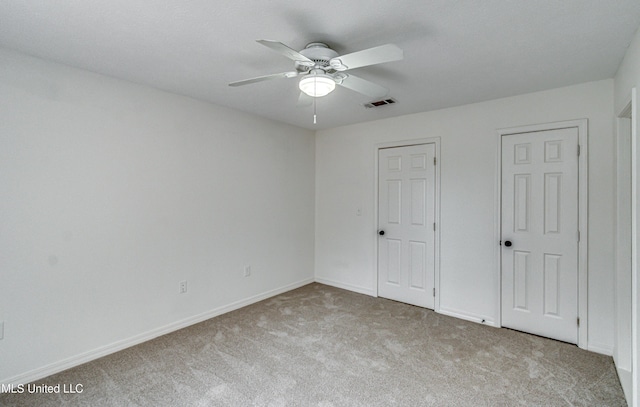 unfurnished bedroom with light colored carpet and ceiling fan