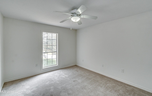 empty room featuring ceiling fan and light carpet