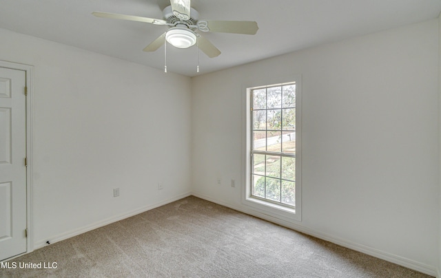 carpeted spare room featuring ceiling fan