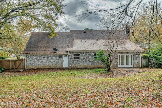 back of property featuring a lawn and french doors