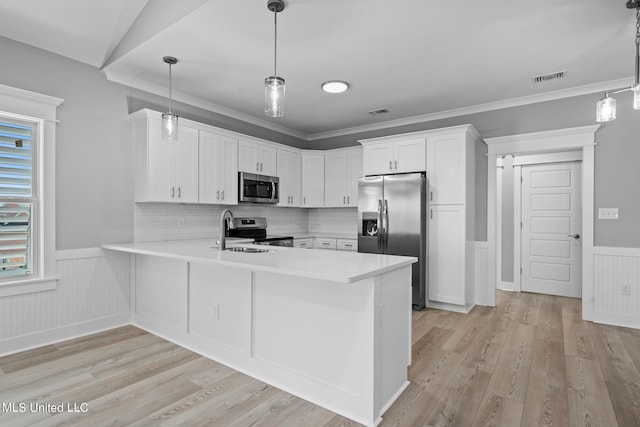 kitchen featuring decorative backsplash, kitchen peninsula, hanging light fixtures, white cabinetry, and appliances with stainless steel finishes