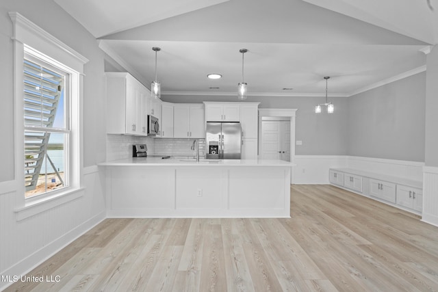 kitchen featuring white cabinets, light wood-type flooring, appliances with stainless steel finishes, and decorative light fixtures