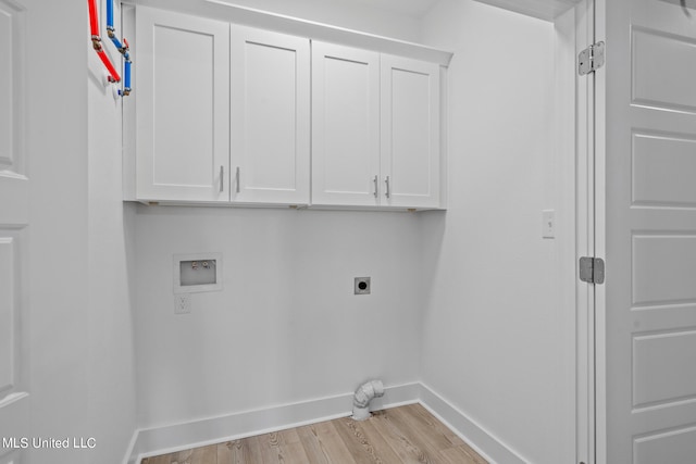 laundry area with hookup for an electric dryer, light hardwood / wood-style floors, washer hookup, and cabinets