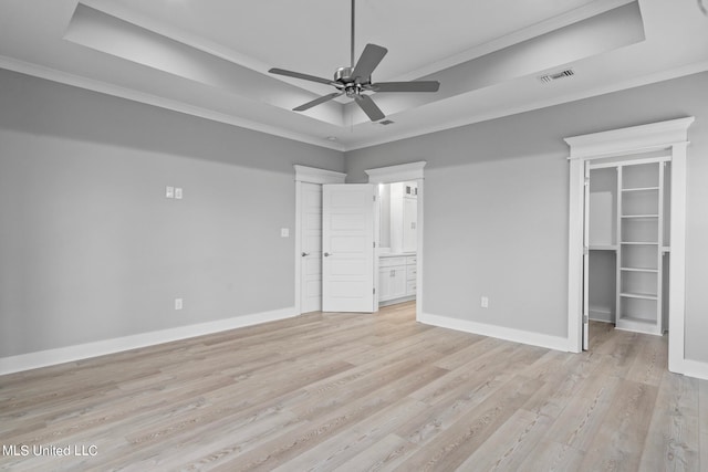 unfurnished bedroom with ceiling fan, light wood-type flooring, a spacious closet, and ornamental molding