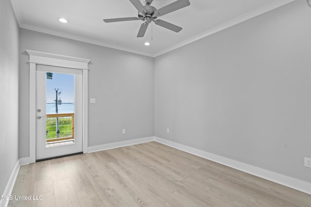 empty room featuring ceiling fan, light wood-type flooring, and ornamental molding