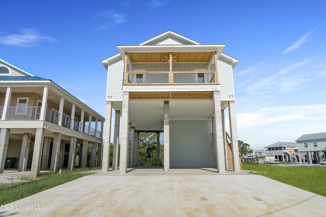 raised beach house featuring a balcony and a carport