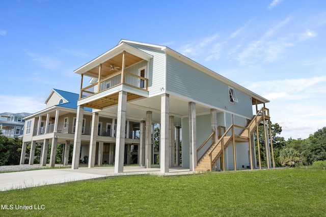 back of property with a yard and a balcony