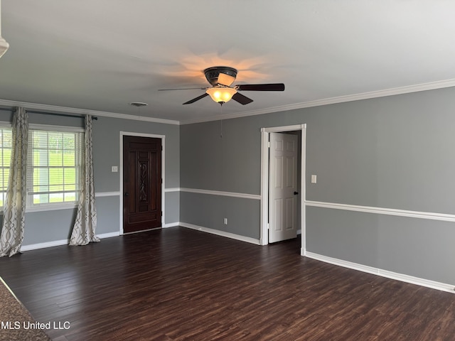 spare room featuring a ceiling fan, baseboards, ornamental molding, and dark wood-type flooring