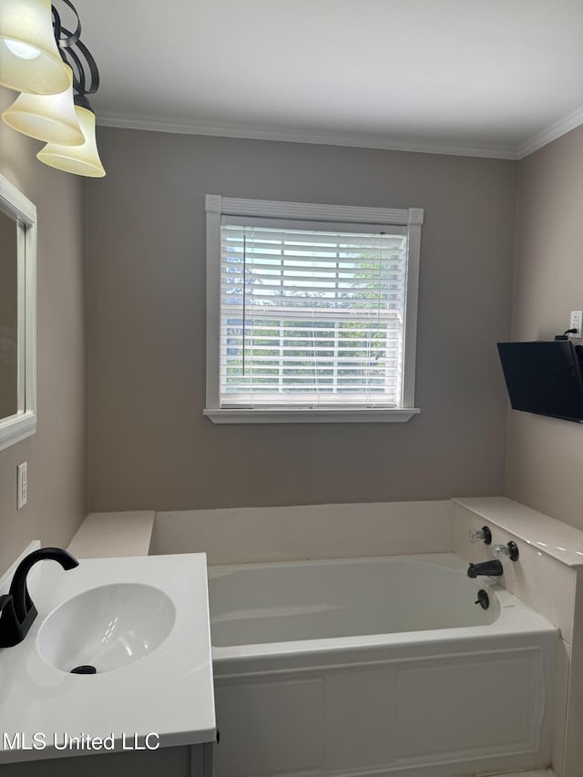 bathroom with ornamental molding, a bath, and vanity