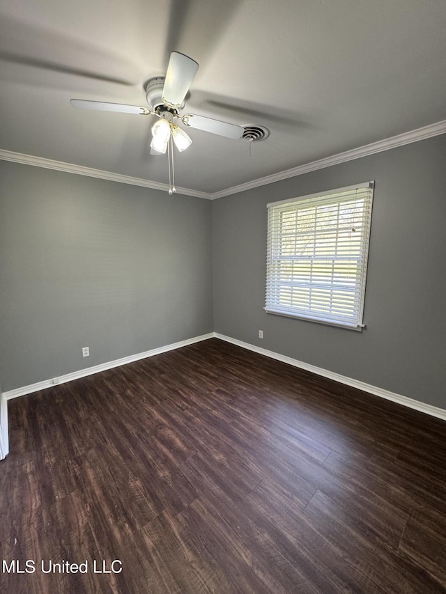 spare room with a ceiling fan, visible vents, crown molding, wood finished floors, and baseboards