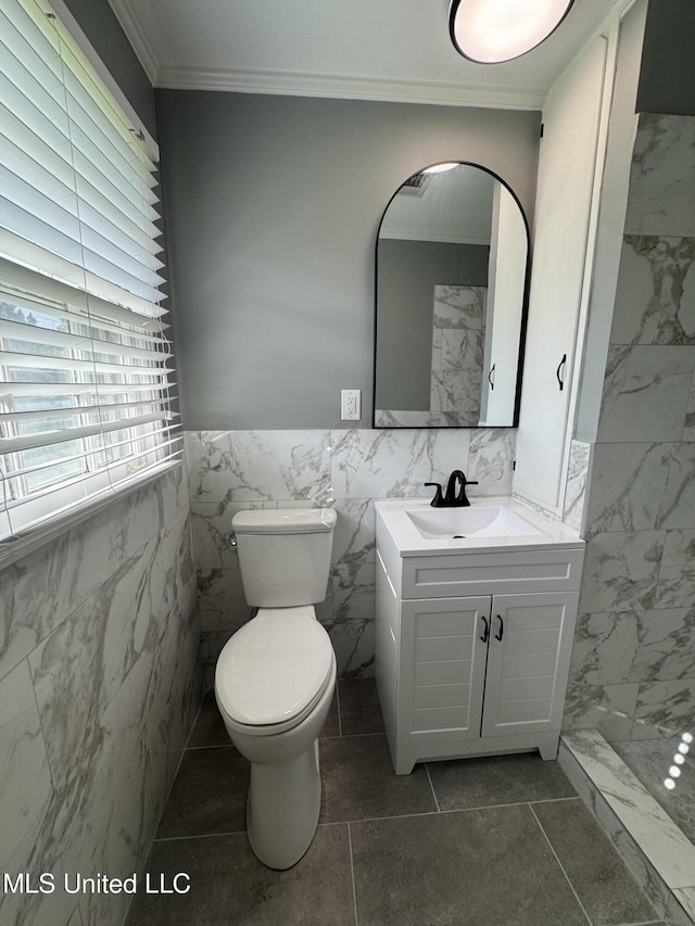bathroom featuring crown molding, walk in shower, vanity, toilet, and tile walls