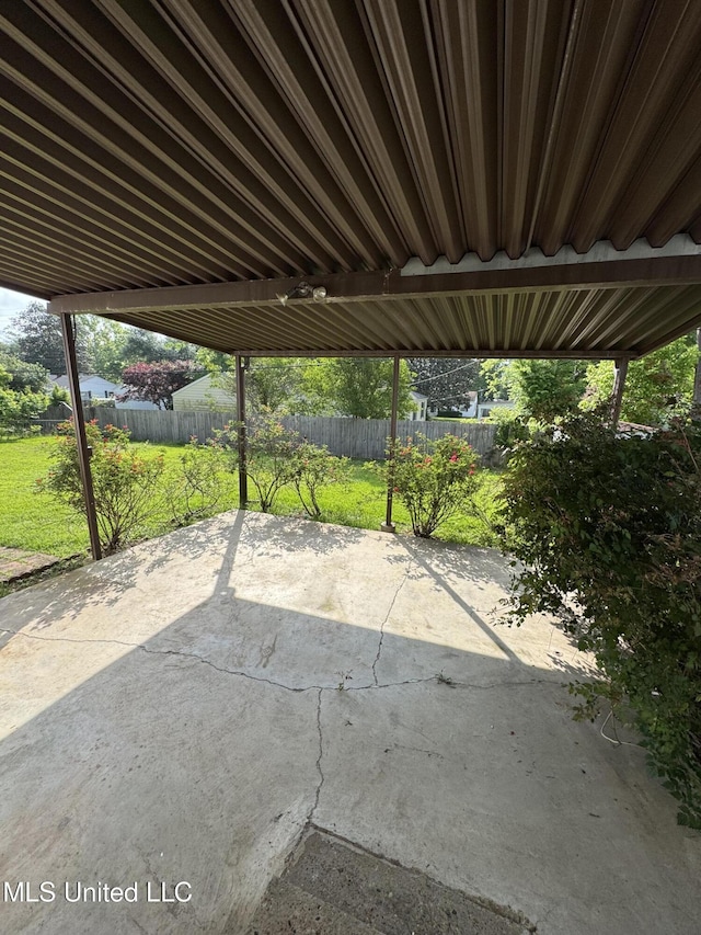 view of patio / terrace with fence and a carport