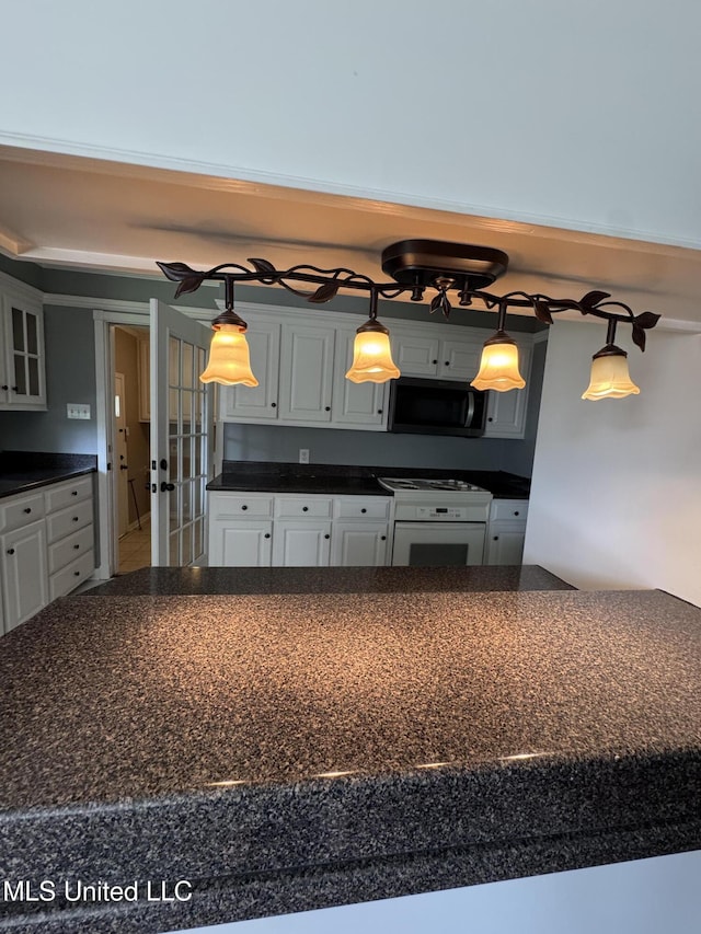 kitchen with french doors, dark countertops, white cabinets, and white range with electric cooktop