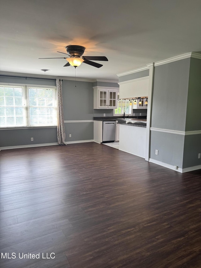 unfurnished living room with baseboards, a sink, dark wood-style flooring, and ceiling fan
