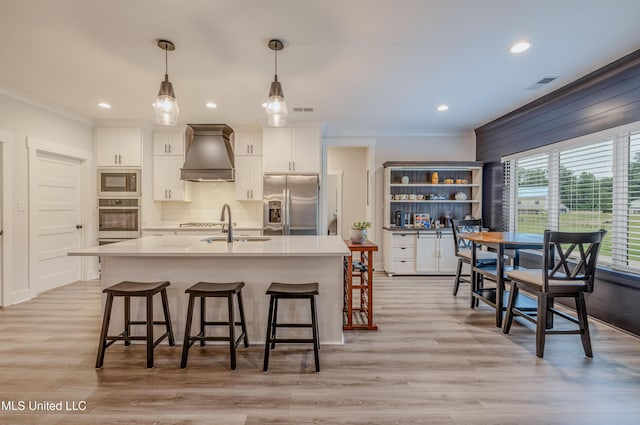 5267 Reserve Way, Hernando, MS 38632 - kitchen with stainless steel appliances, premium range hood, ornamental molding, a kitchen breakfast bar, and white cabinetry