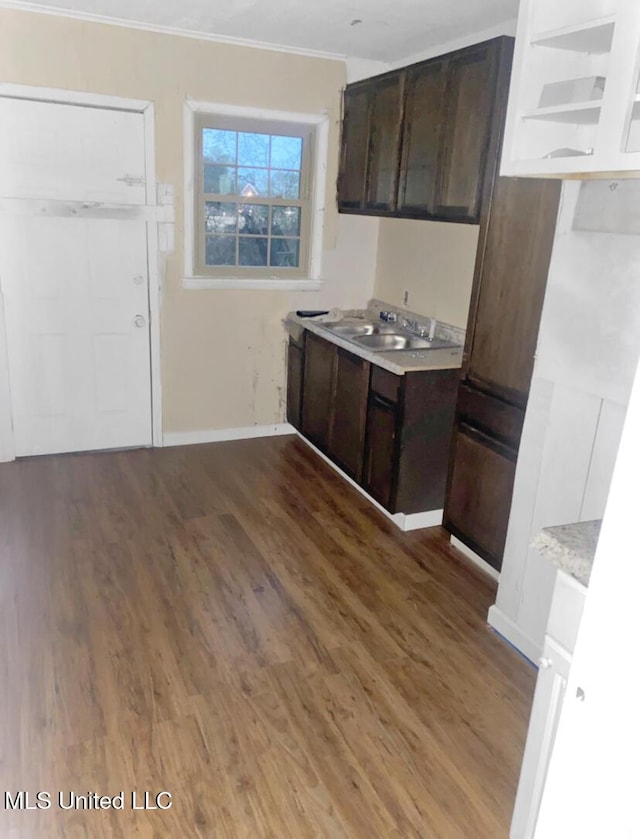 kitchen featuring sink, crown molding, hardwood / wood-style flooring, and dark brown cabinets