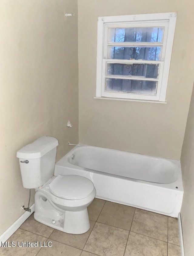 bathroom featuring toilet, tile patterned flooring, and a bathing tub