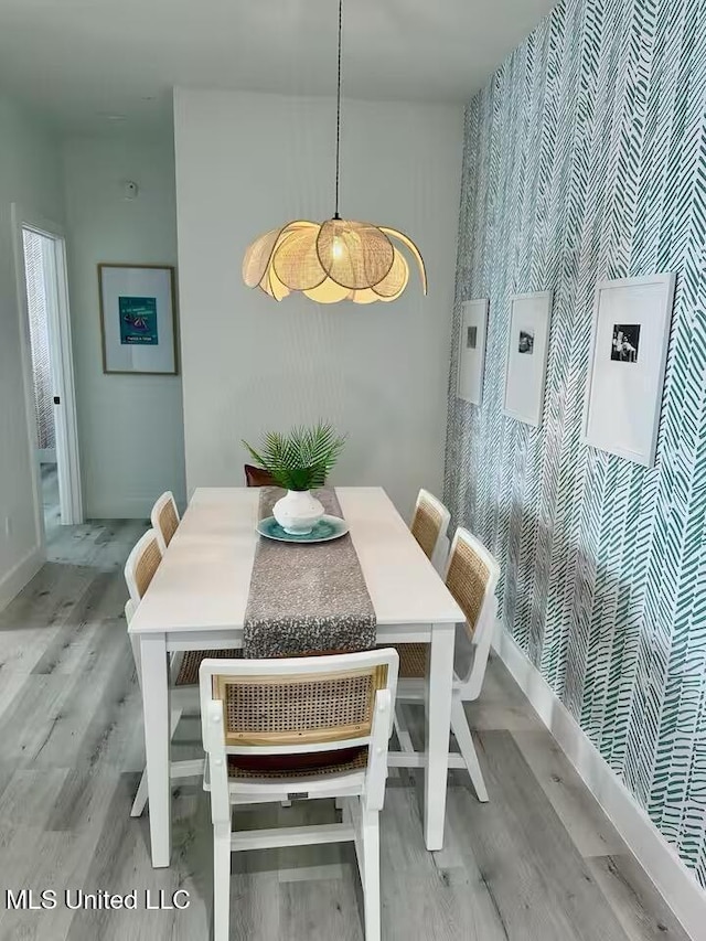 1302 Magnolia St Unit 202, Gulfport, MS 39507 - dining area with an accent wall, wood finished floors, and wallpapered walls