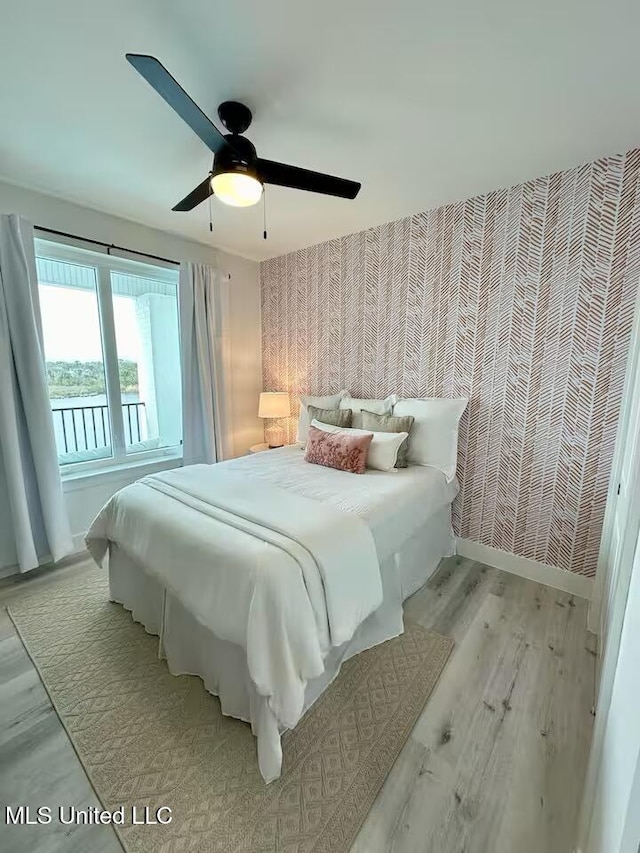1302 Magnolia St Unit 202, Gulfport, MS 39507 - bedroom with light wood-style floors, ceiling fan, and wallpapered walls