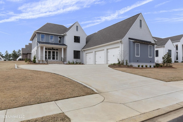 view of front of home featuring a front yard, covered porch, driveway, and an attached garage