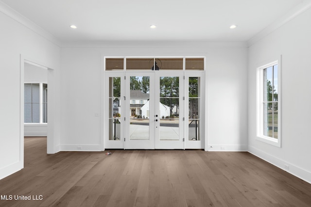 doorway to outside featuring crown molding, baseboards, and wood finished floors