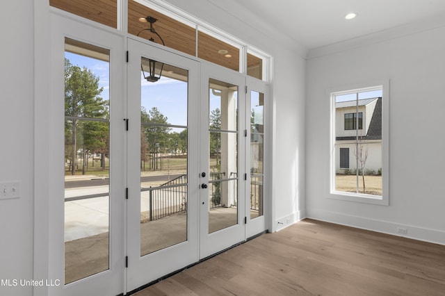 doorway to outside with ornamental molding, recessed lighting, baseboards, and wood finished floors