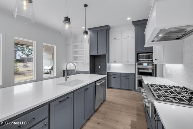 kitchen with stainless steel appliances, light countertops, custom range hood, and a sink